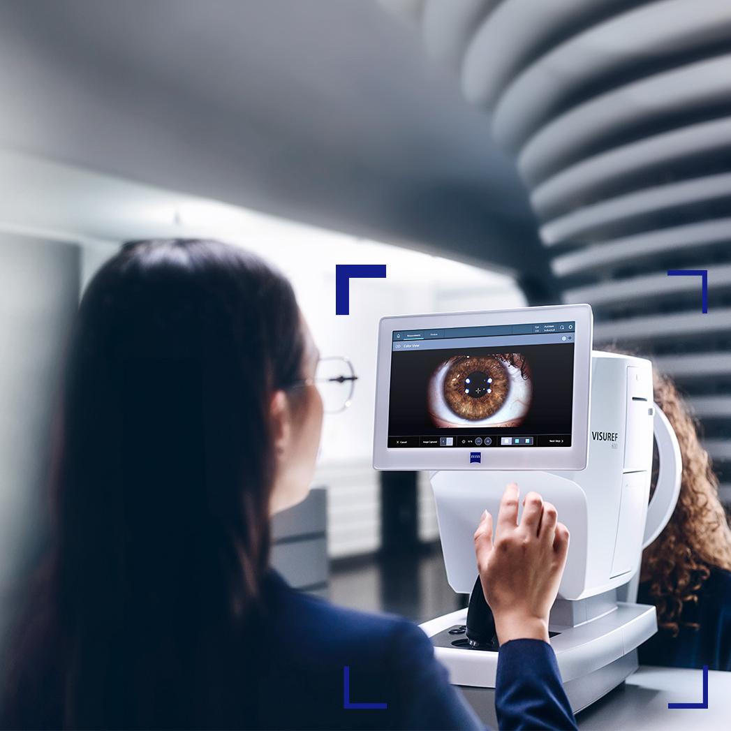 Optómetra mirando la pantalla del equipo ZEISS VISUREF 600 que muestra la imagen de un ojo.