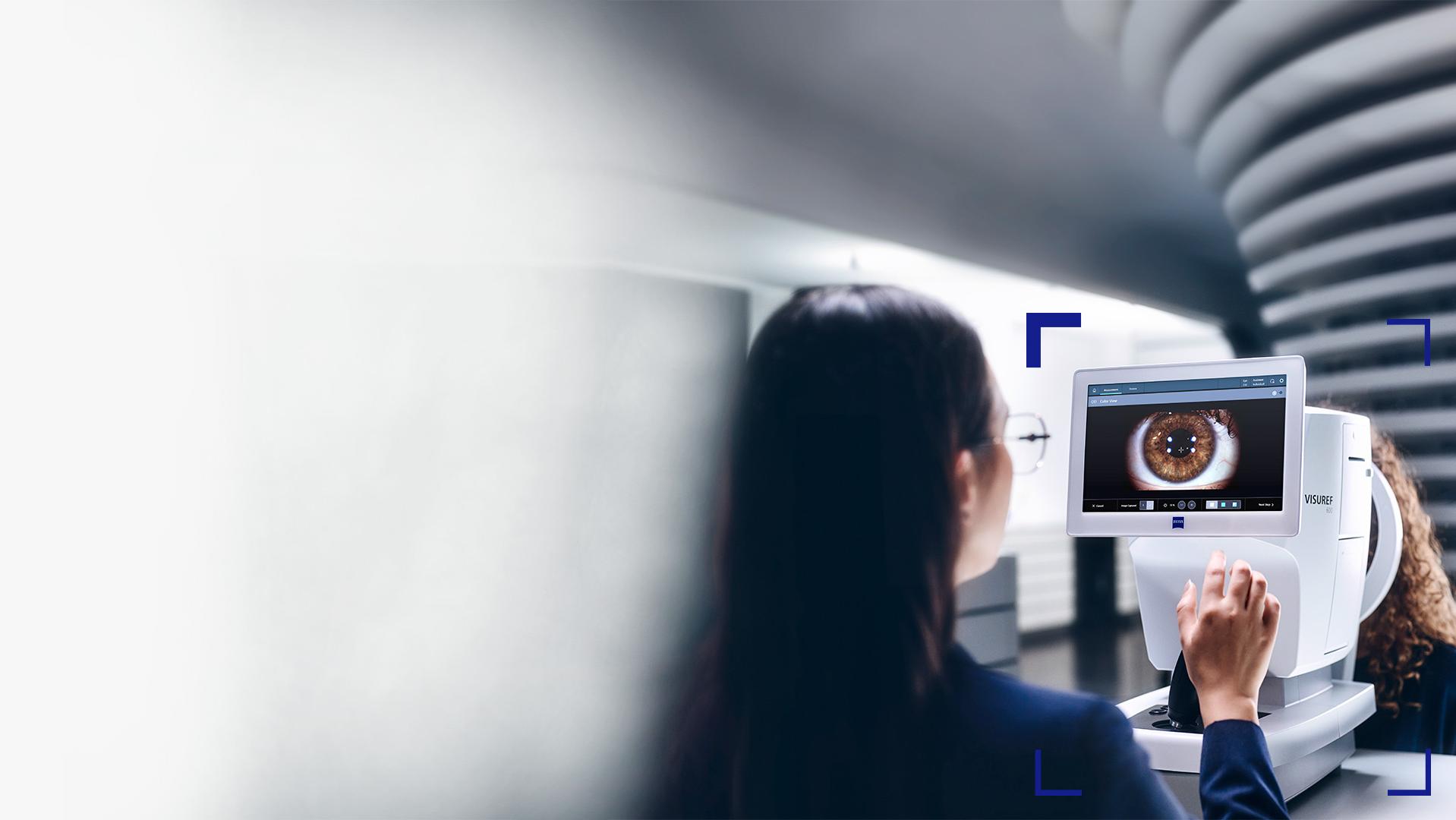 Optómetra mirando la pantalla del equipo ZEISS VISUREF 600 que muestra la imagen de un ojo.