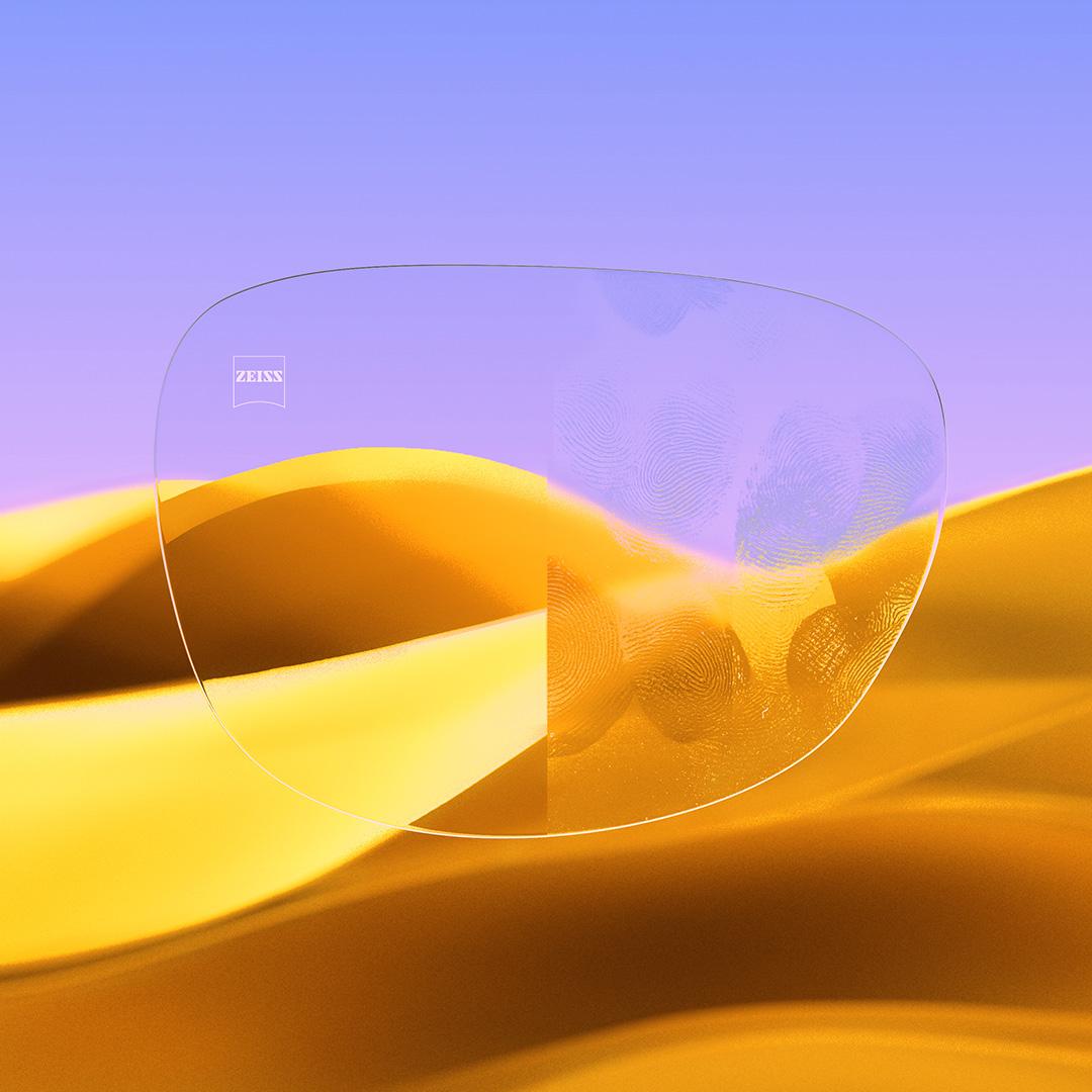 Lente con prescripción dividido: con un lado transparente y limpio con ZEISS DuraVision Gold UV y un lado con huellas que cubren el lente.