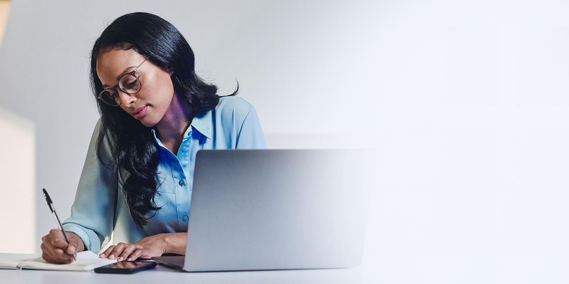 Woman with glasses working on laptop