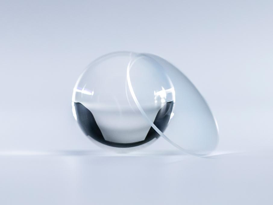 Un lente con recubrimiento ZEISS Platinum es transparente sin reflejos en comparación con la bola de cristal que tiene al lado.