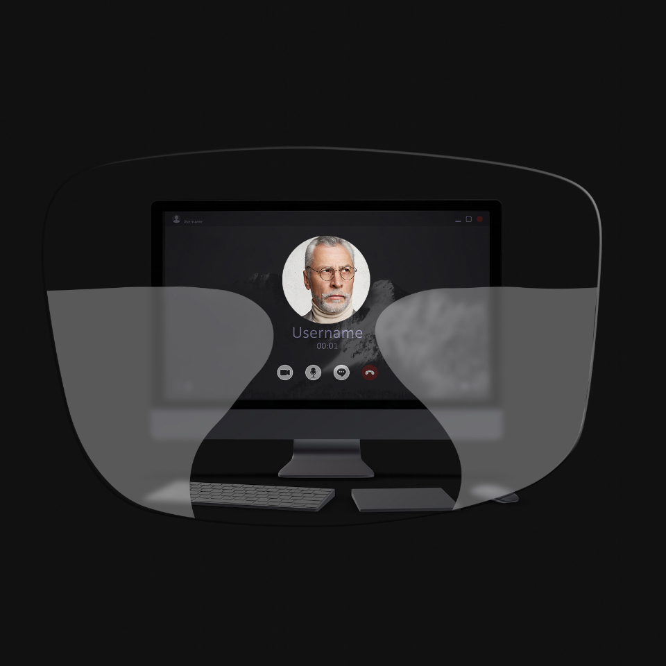 La vista de un computador de mesa, un teclado, un ratón y un libro a través de una ilustración esquemática de unos lentes progresivos muestra que las zonas de visión cercana e intermedia son demasiado pequeñas para ver con nitidez la pantalla.