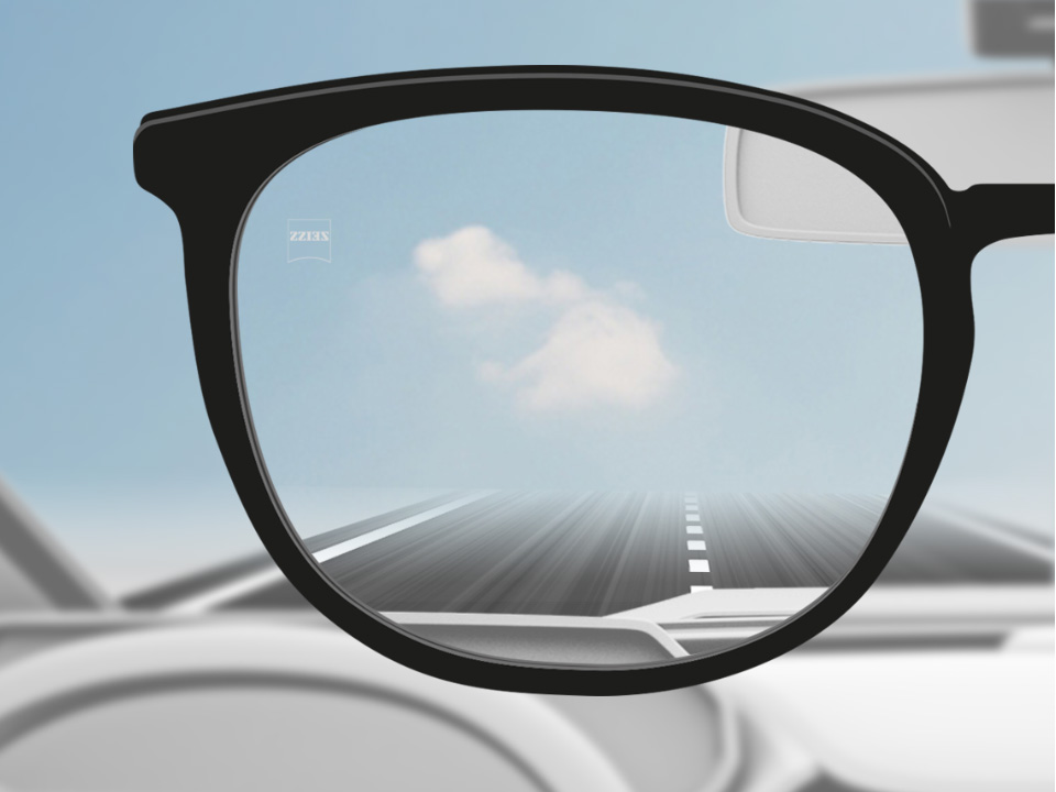 Ilustración de un punto de vista esquemático a través de un lente de visión sencilla DriveSafe que muestra una vista nítida de la carretera. . 