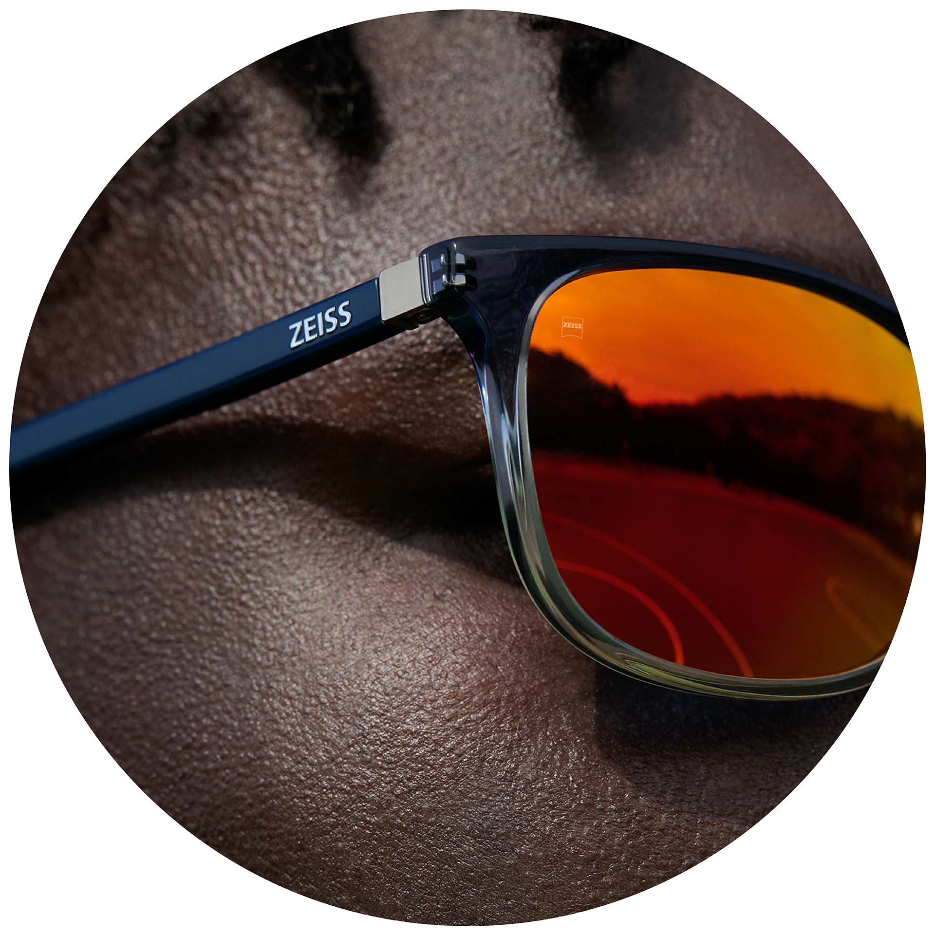 Un hombre con gafas ZEISS con lentes graduados para gafas de sol con recubrimientos espejados en naranja.