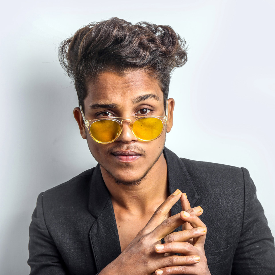 Un joven con lentes de sol con tinte amarillo.