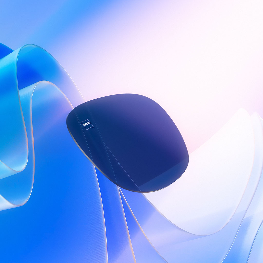 Se muestra una representación por CGI de un lente tintado flotando hacia la luz del sol, lo que ilustra su capacidad para bloquear los rayos UV.