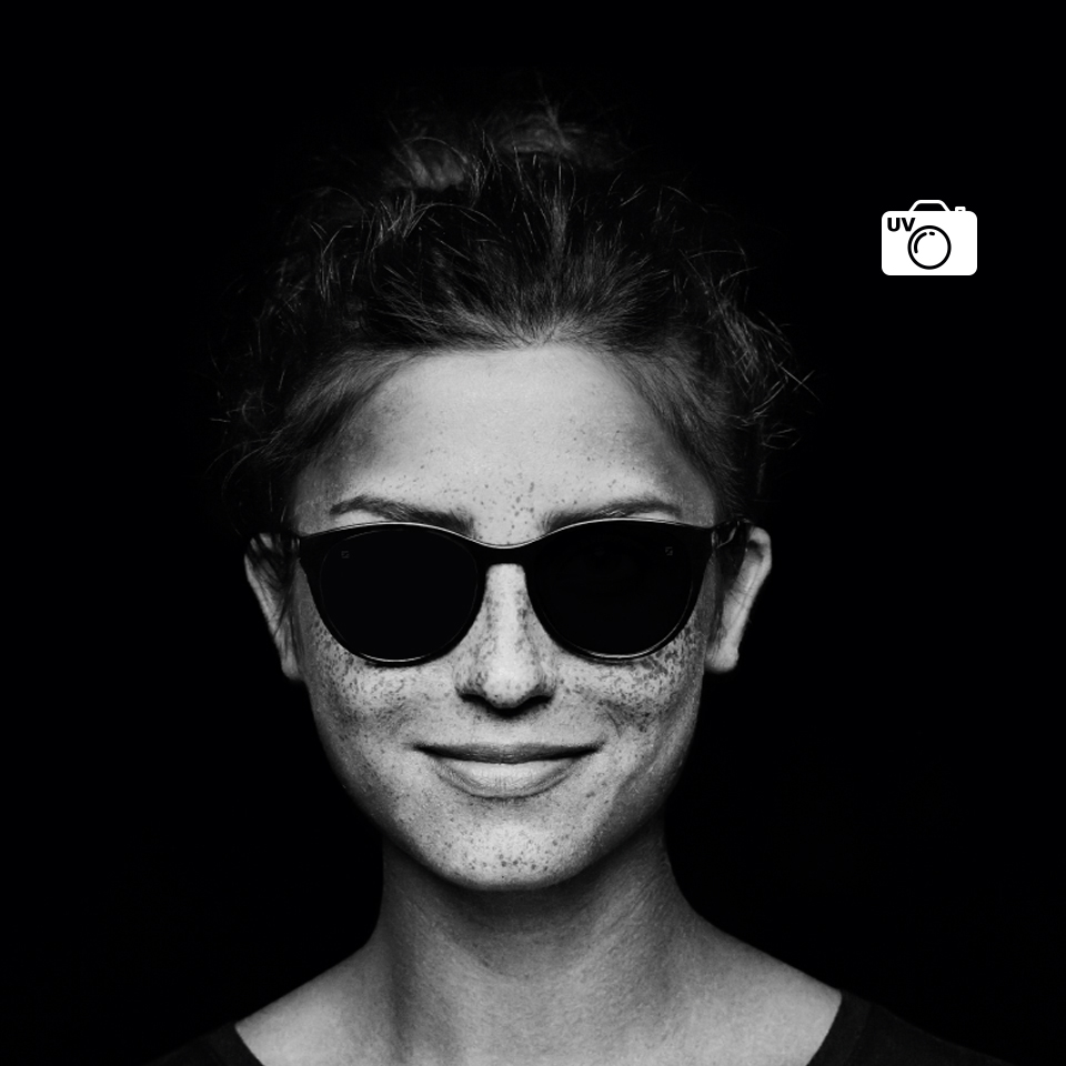 La misma mujer con lentes transparentes, vista a través de una cámara normal y el lente de una cámara UV. Con una cámara UV, el lente parece negro, lo que indica que no deja pasar los rayos UV.  
