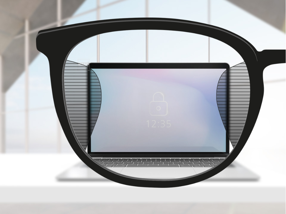 Una imagen desde el punto de vista de unos lentes ZEISS Office, con la pantalla de una computadora enfocada en el centro del lente y áreas laterales ligeramente borrosas a ambos lados.