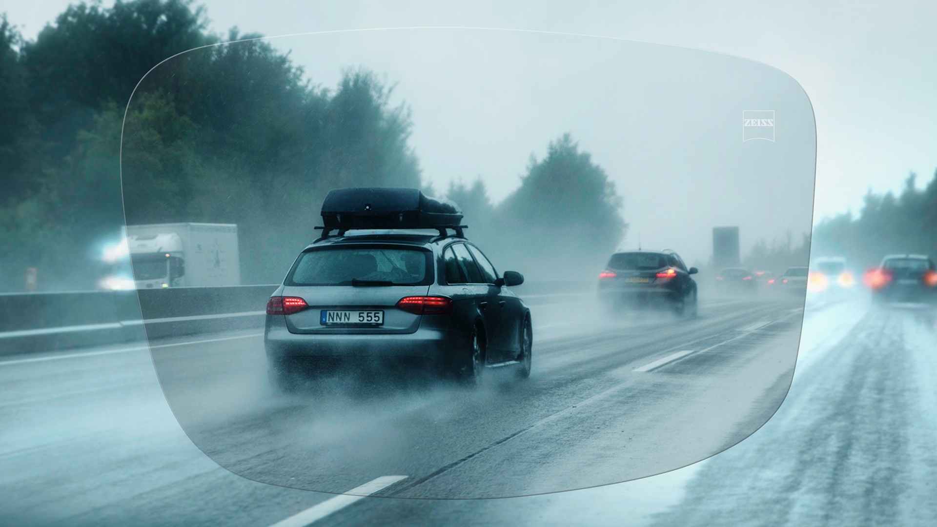 Vista a través de un lente de visión sencilla ZEISS DriveSafe Individual de una carretera en un día de lluvia 