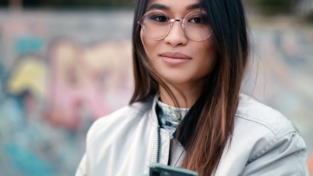 Una joven en una pista de skate con lentes de visión sencilla ZEISS SmartLife.
