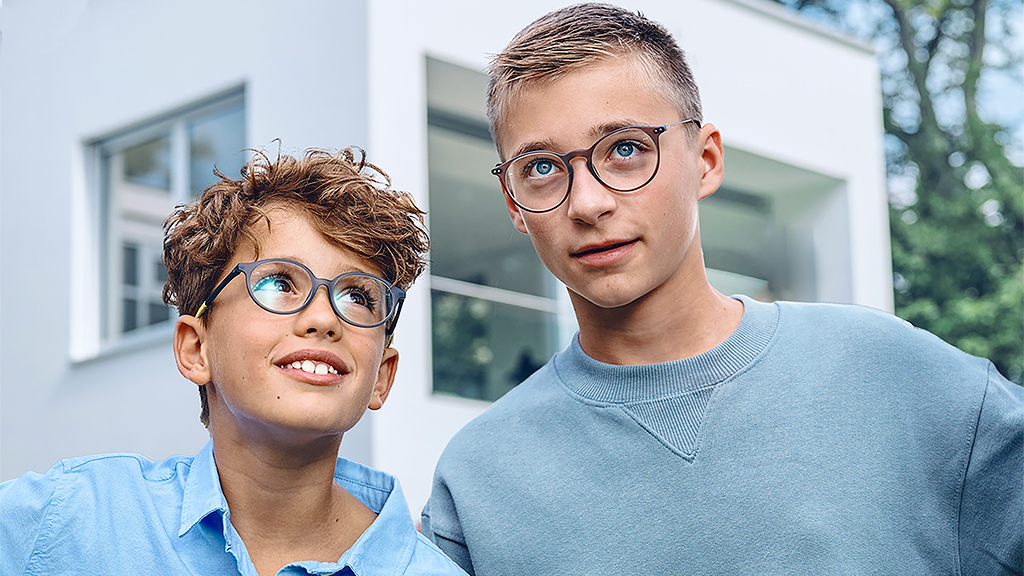 Un joven mirando a un adolescente, ambos con lentes monofocales ZEISS SmartLife Young